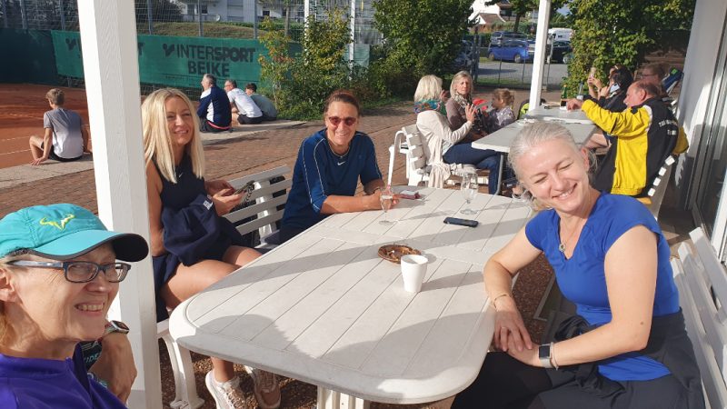 Tennis-Mitgliederinnen bei wunderbarem Herbstwetter beim beliebte Mixed-Doppel-Turnier sitzen an mehreren Tischen auf der Terasse und genießen die Sonne