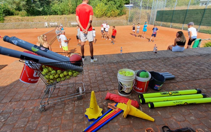 Mehrere Kinder und Jugendliche bei diversen Übungen im Freien auf dem Tennisplatz