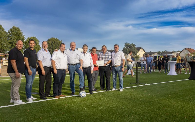 Einweihung Kunstrasenplatz 07.08.2026. Gruppenfoto auf dem Platz: Michael Seifert (1. Vorsitzender TSG Mainflingen), Dirk Breuhahn (Abteilungsleitung Fußball), Frank Lortz (Vizepräsident des hessischen Landtags), Carsten Müller (Erster Kreisbeigeordneter und stellvertretender Landrat), Frank Simon (Bürgermeister Mainhausen), Klaus Tinnefeld (Vorstandsvorsitzender Sparkasse Langen-Seligenstadt), Thomas Geiß (Sparkasse Langen-Seligenstadt), Jörg Wagner (Kreißfussballwart und Vorsitzender Sportkreis Offenbach) und Marcel Subitil (Kreis Offenbach)