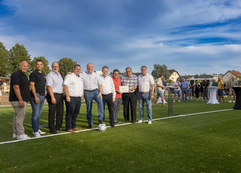 Einweihung Kunstrasenplatz 07.08.2026. Gruppenfoto auf dem Platz: Michael Seifert (1. Vorsitzender TSG Mainflingen), Dirk Breuhahn (Abteilungsleitung Fußball), Frank Lortz (Vizepräsident des hessischen Landtags), Carsten Müller (Erster Kreisbeigeordneter und stellvertretender Landrat), Frank Simon (Bürgermeister Mainhausen), Klaus Tinnefeld (Vorstandsvorsitzender Sparkasse Langen-Seligenstadt), Thomas Geiß (Sparkasse Langen-Seligenstadt), Jörg Wagner (Kreißfussballwart und Vorsitzender Sportkreis Offenbach) und Marcel Subitil (Kreis Offenbach)